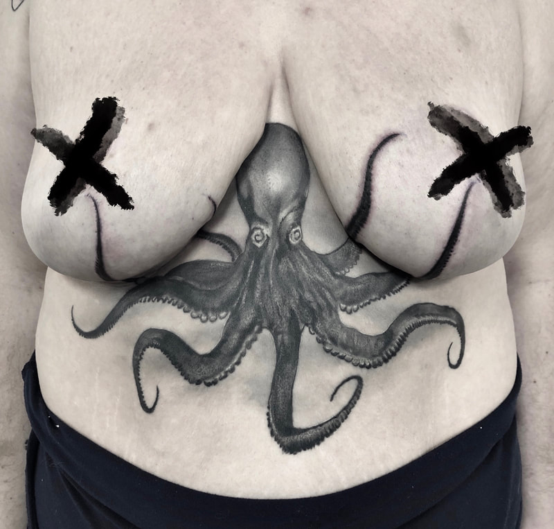 Realistic black and gray octopus under bust tattoo.