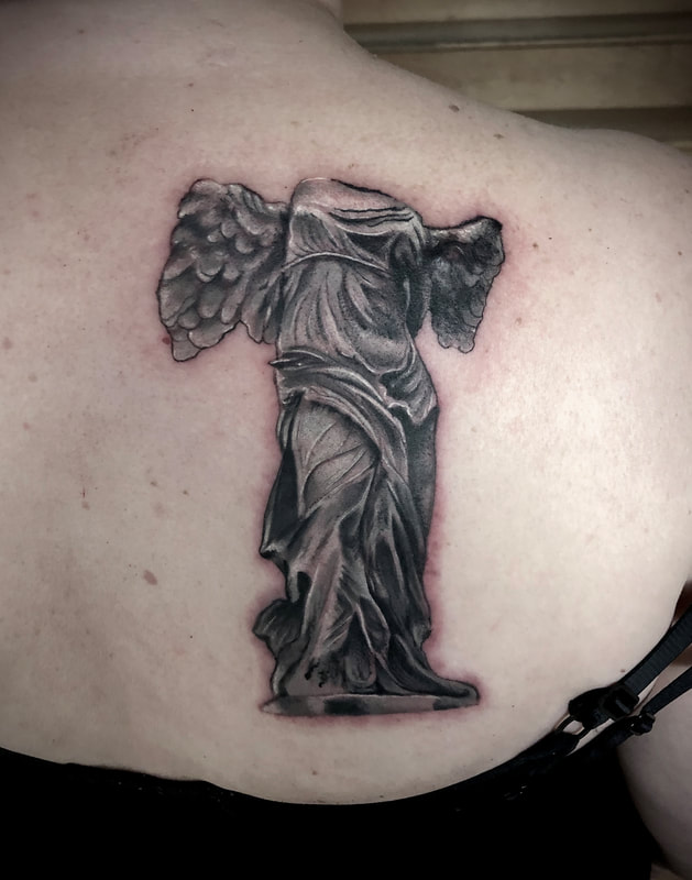 Realistic black and gray statue of “the victory of Samothrace” tattoo.